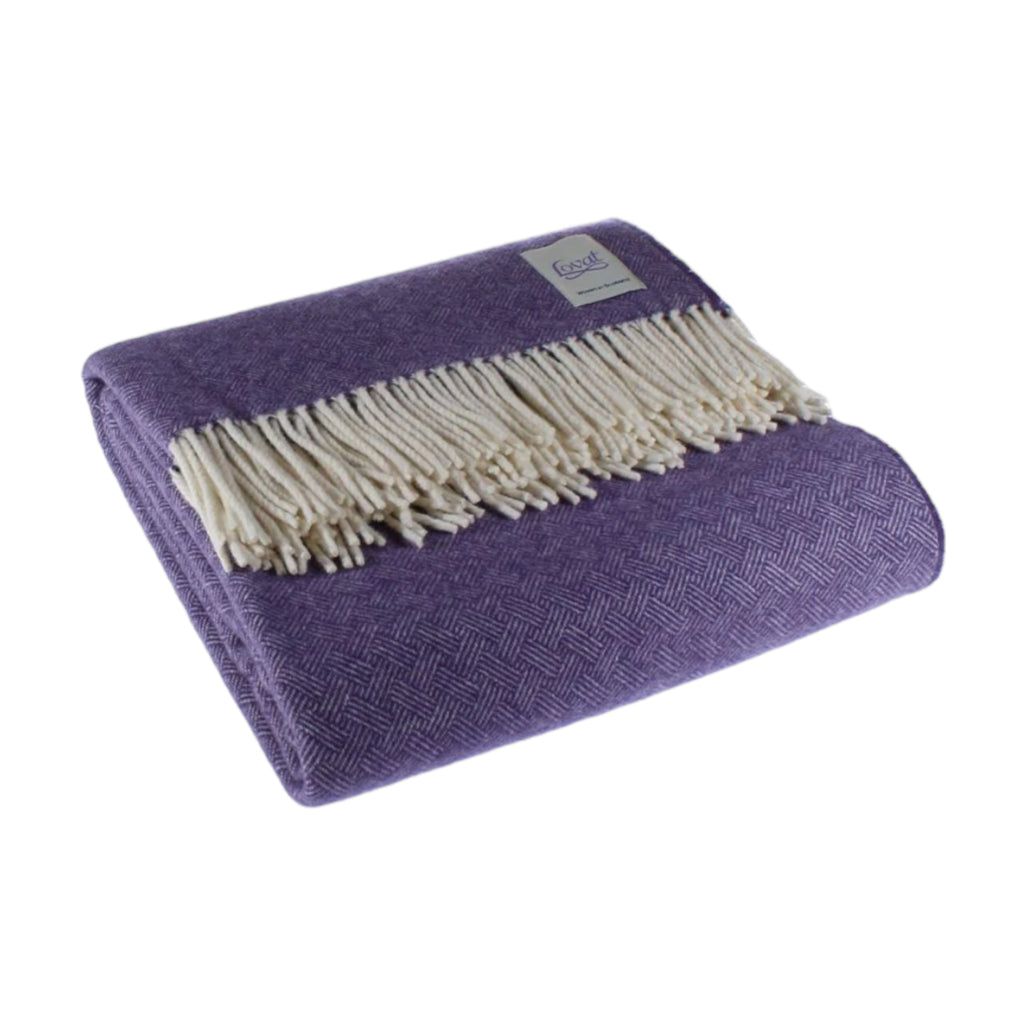 A folded heather purple wool blanket with a diamond border pattern and fringe.