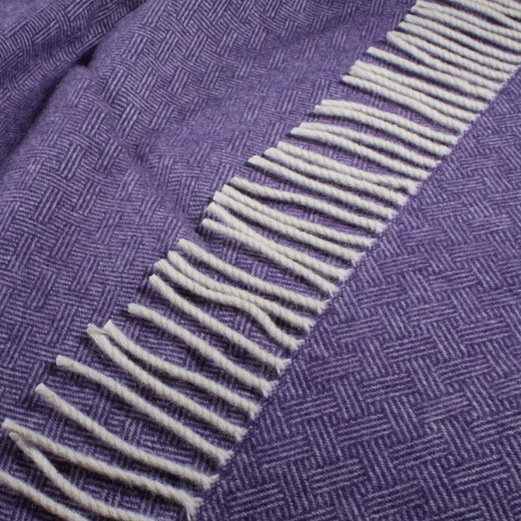 A up close shot of the heather purple lambswool blanket fringing.