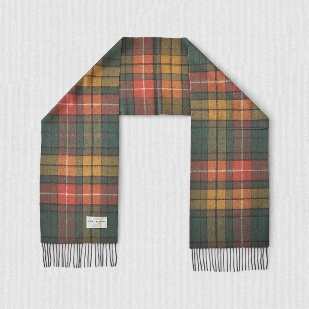 A tartan scarf with Antique Buchanan tartan, featuring a mix of gold, green, and red colors, laid out on a plain surface.
