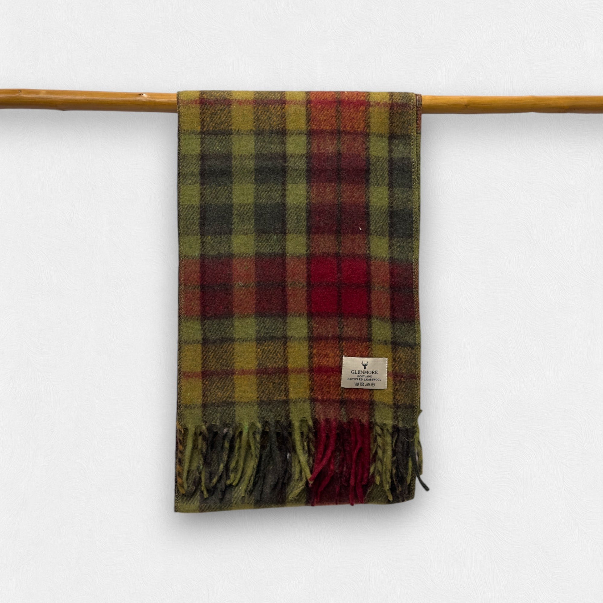 A autumn buchanan scarf hanging on a wooden rod against a white background, with a small label visible on the lower side.