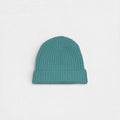 Teal knit beanie on a light gray background