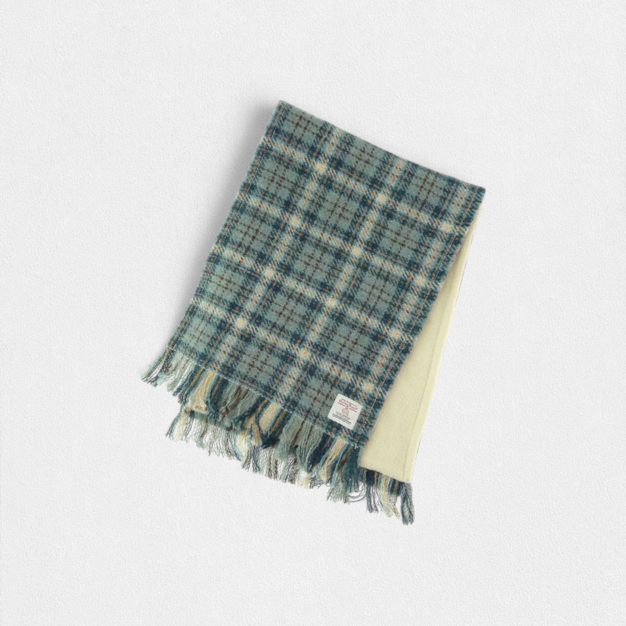 A green and white checkered Harris Tweed scarf with fleece lining, displayed on a plain background.