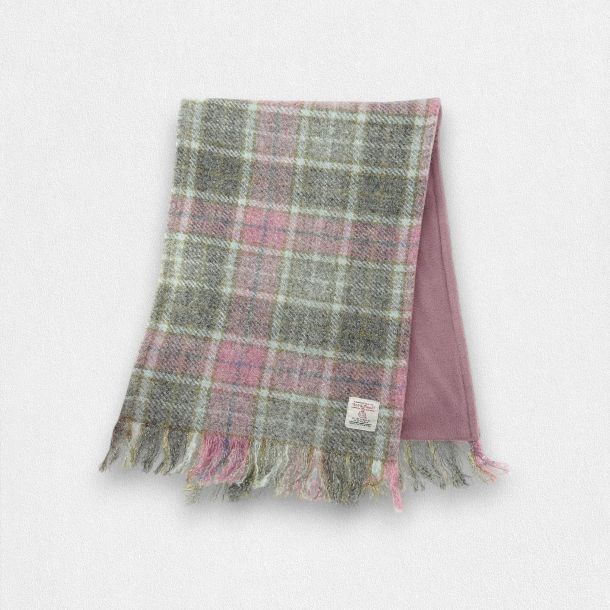 A grey and pink checkered Harris Tweed scarf with fringes displayed on a plain background.