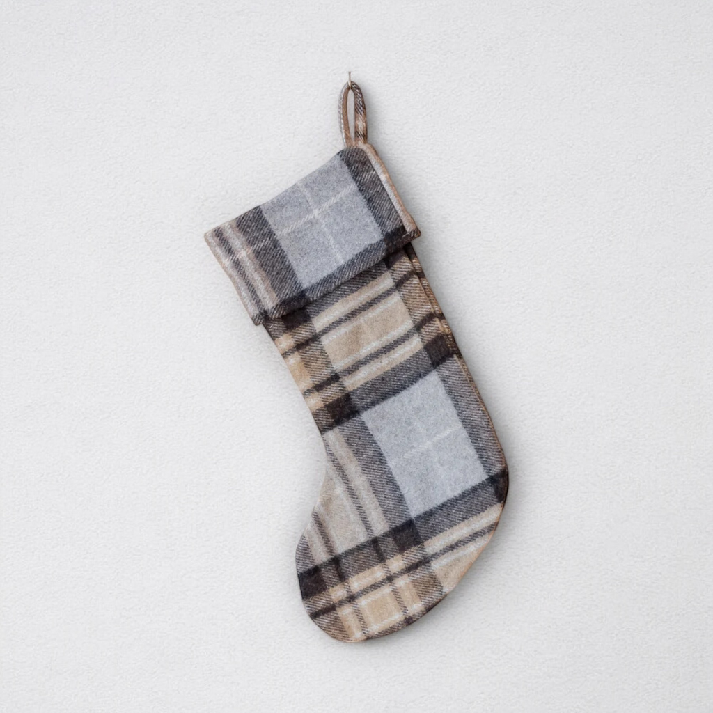 A Christmas stocking with MacKellar tartan, primarily in brown and grey, hanging against a white background.