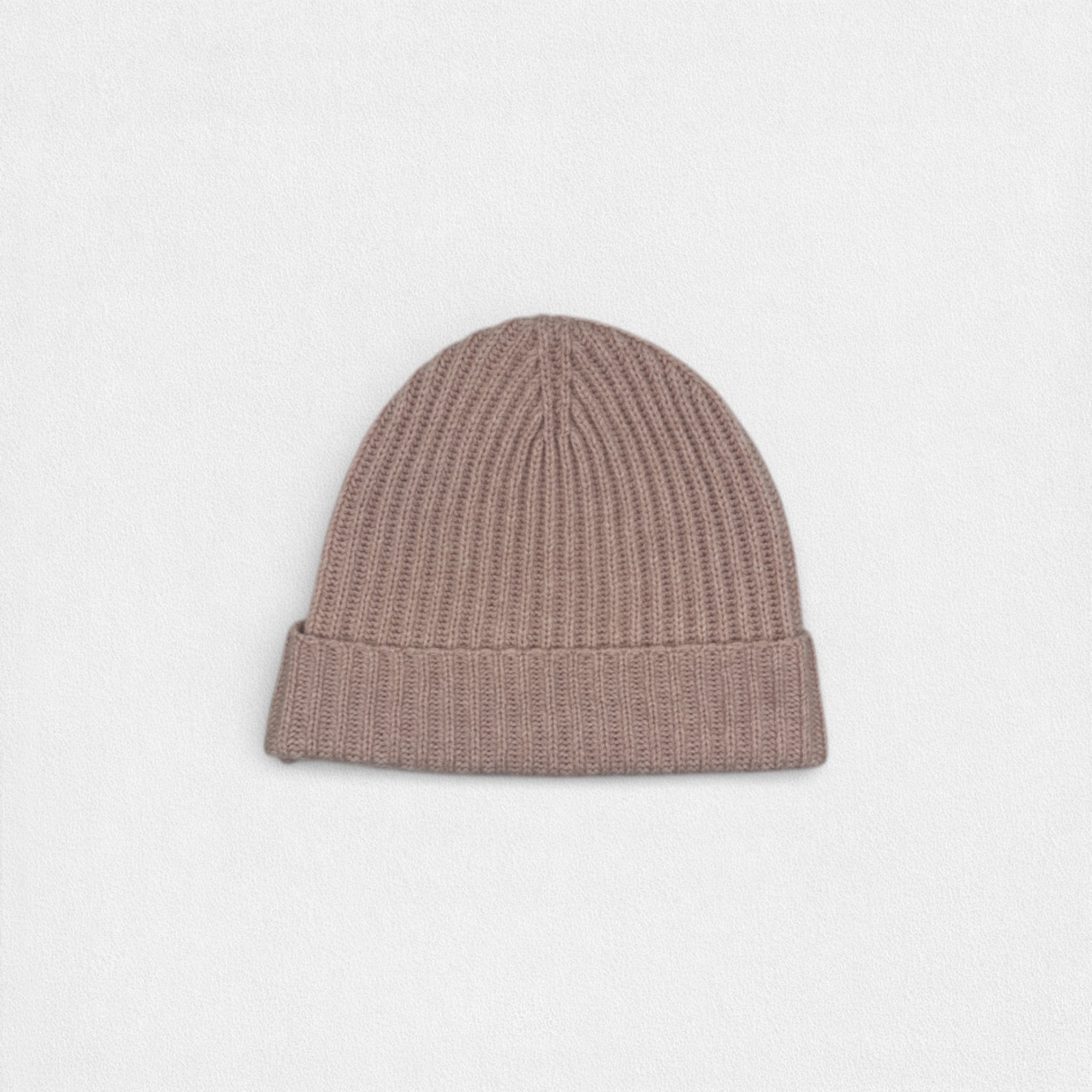 Neutral pink tone cashmere beanie on white background.