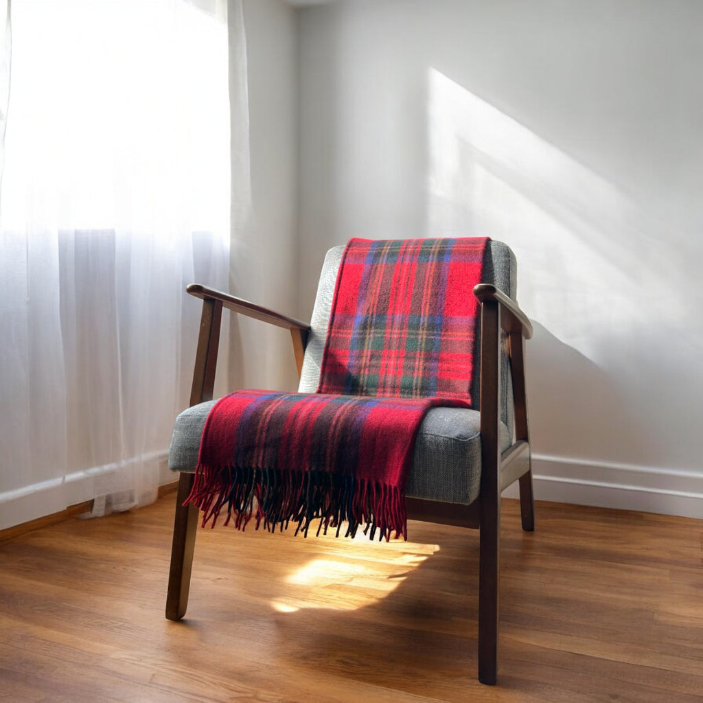 a royal stewart tartan 100% recycled wool  blanket draped over a chair in a cosy room