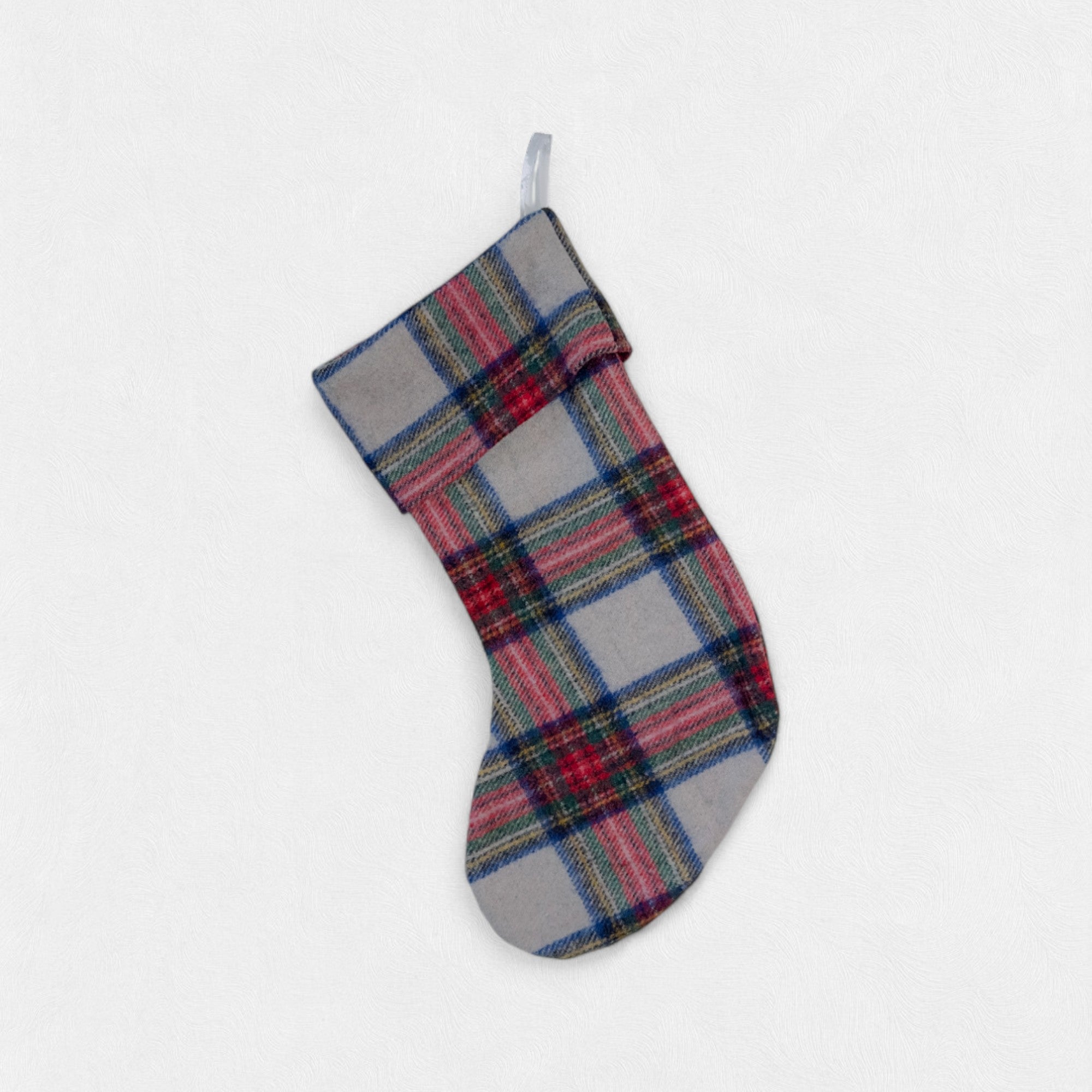 A Stewart Dress Christmas Stocking hanging from a hook on a white background.