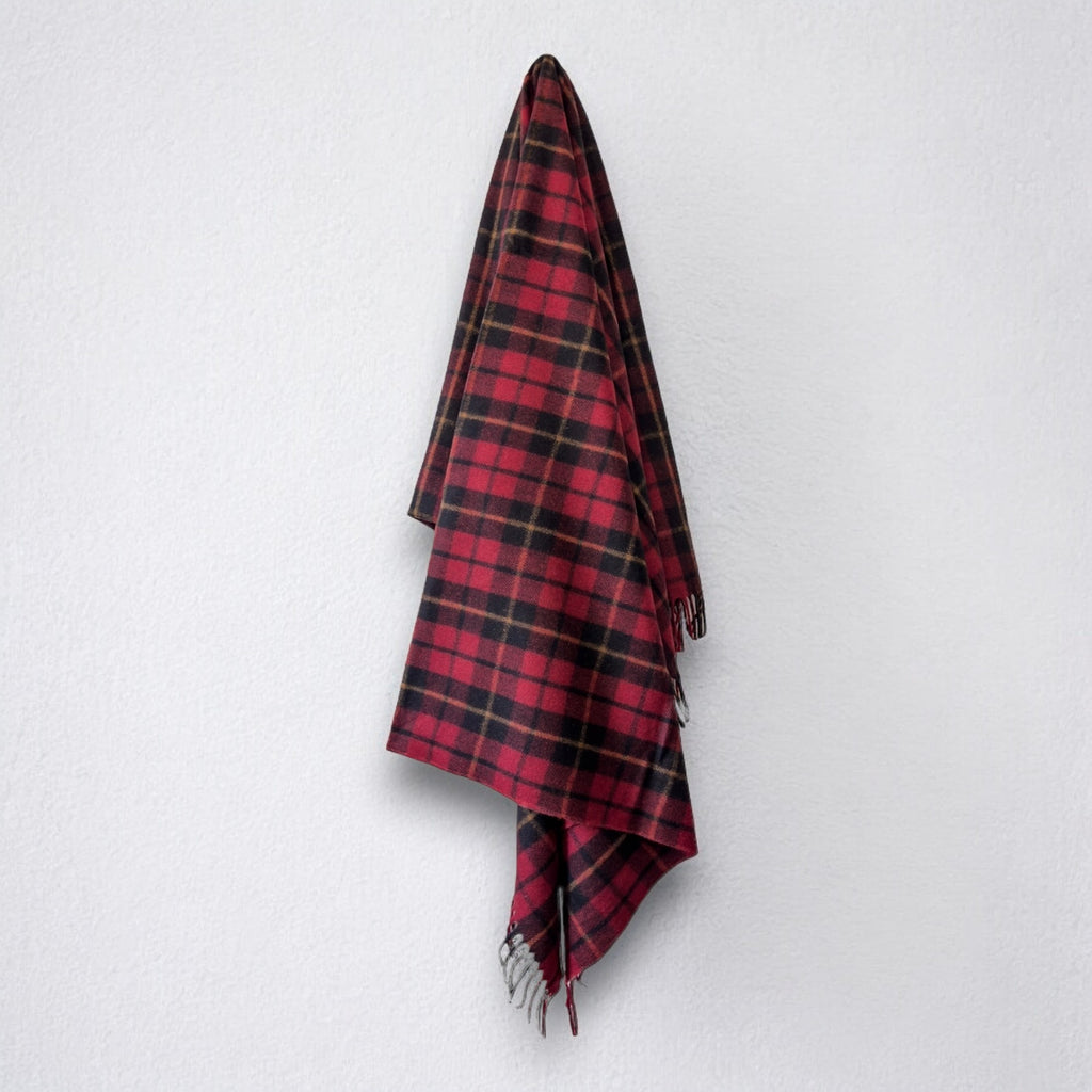 a 100% recycled blanket in wallace tartan hanging from a wall hook on a white background 