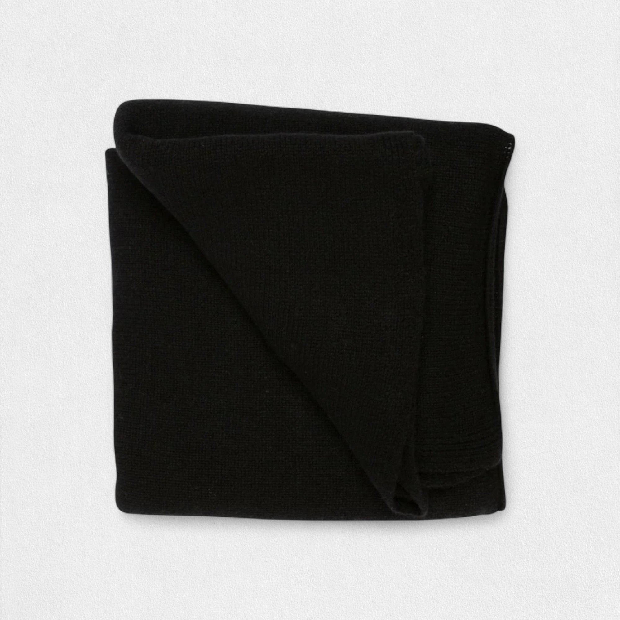 A folded black cashmere blanket displayed on a white background.